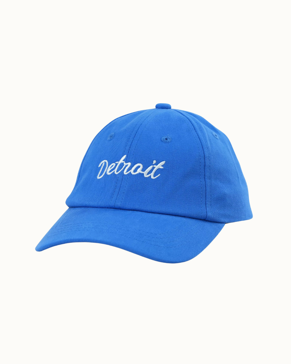 A bright blue baseball cap with 'Detroit' embroidered in white script on the front, shown against a plain off-white background.
