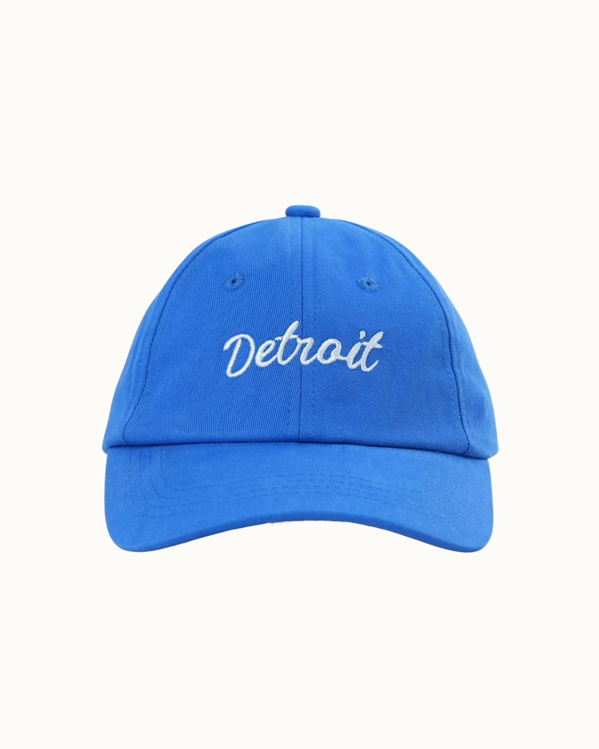 A bright blue baseball cap with 'Detroit' embroidered in white script across the front, shown against a plain off-white background.