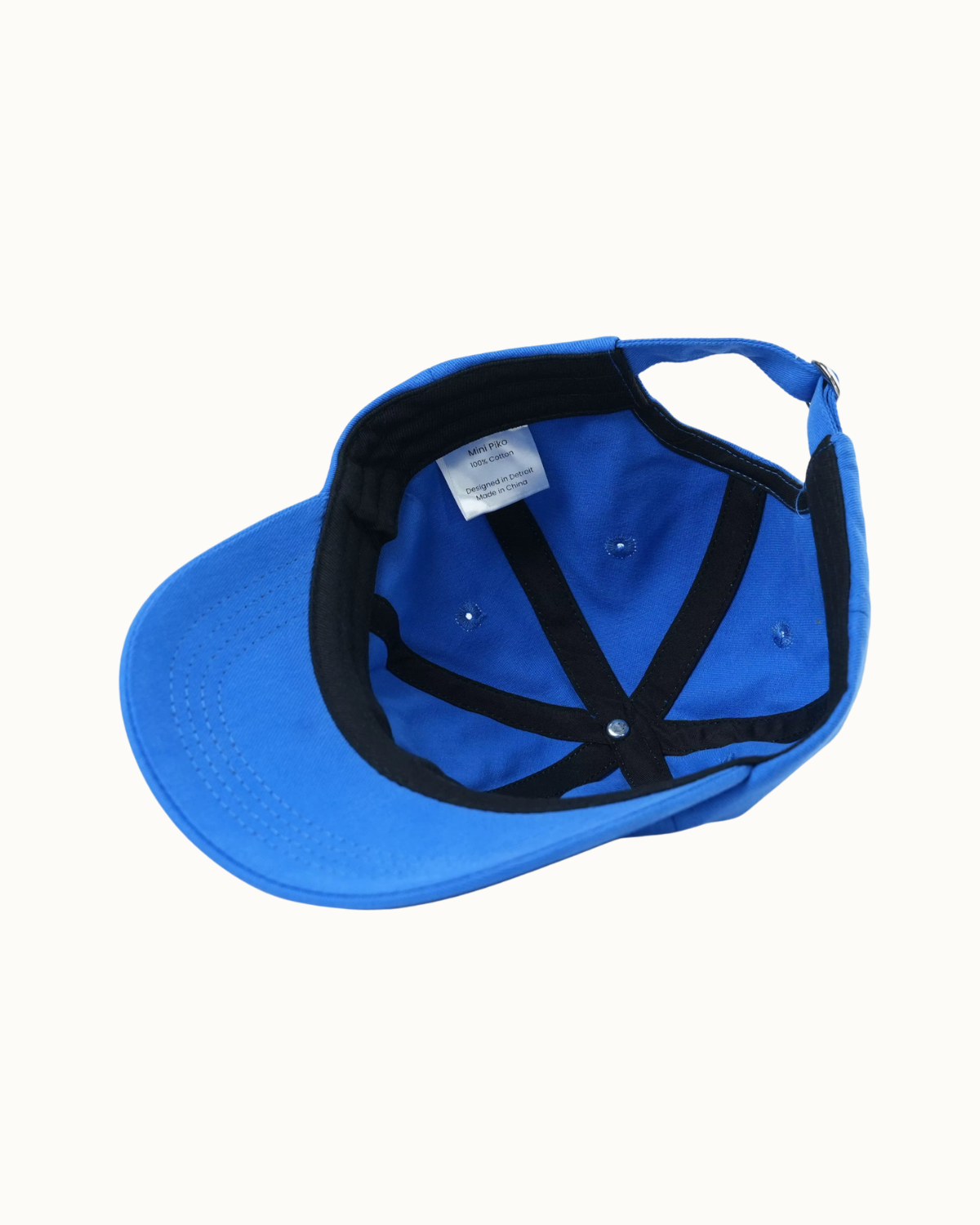 A bright blue baseball cap shown from an overhead angle, revealing a black adjustable interior with black straps and a white size label.